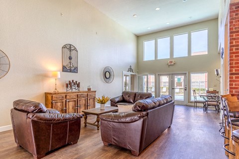 a living room with leather furniture and a brick wall